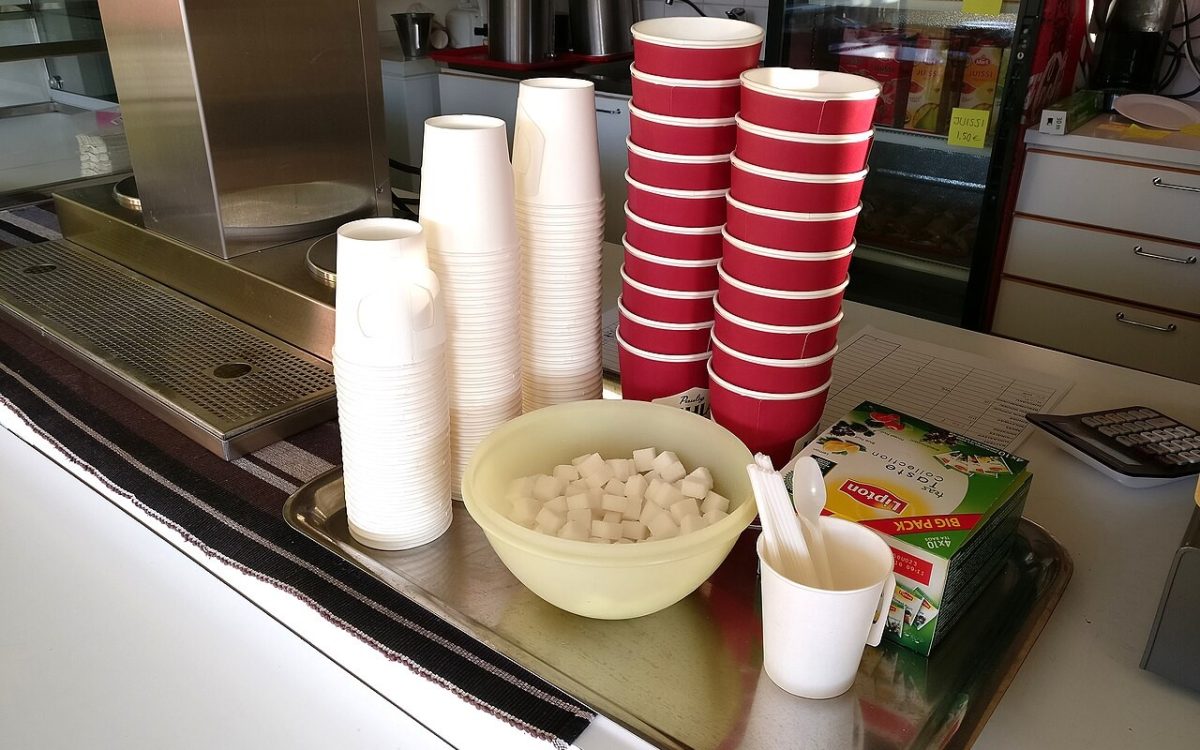 Paper coffee cups and sugar cubes in cafeteria.
