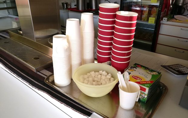 Paper coffee cups and sugar cubes in cafeteria.