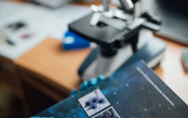 Trabajo de laboratorio con microscopio. Fotografía referencial sobre investigación del envejecimiento.