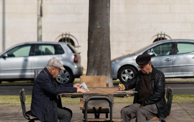 Dos hombres mayores leyendo y resolviendo un crucigrama. Fotografía referencial.