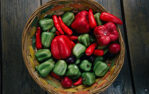 Cesta con pimientos y otras verduras frescas.