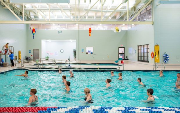 Clase de ejercicio acuático en piscina. Fotografía referencial.