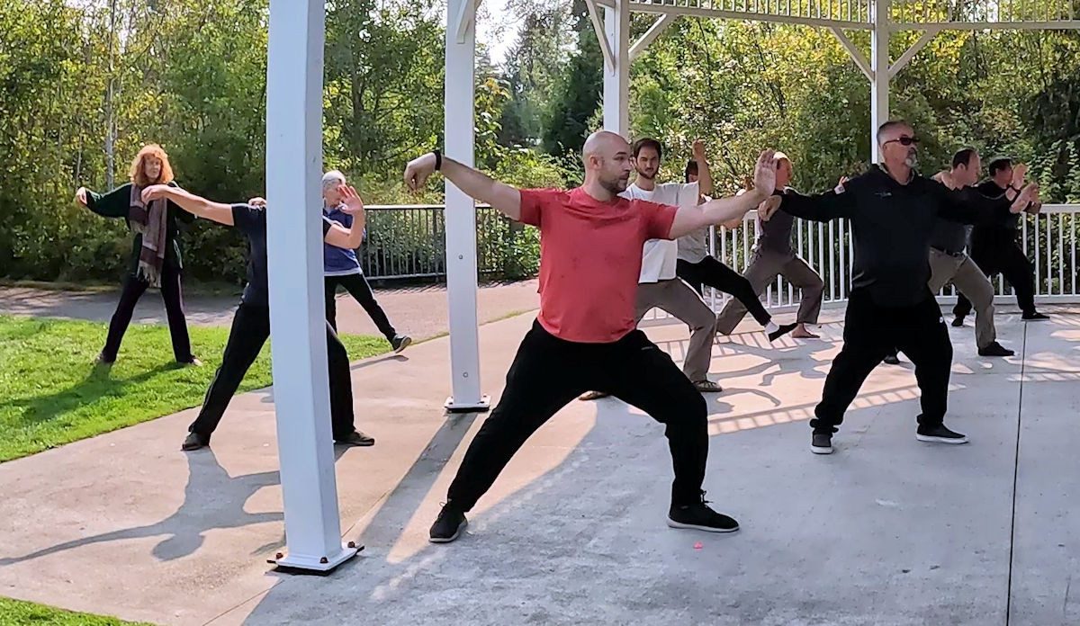Personas practicando tai chi en un parque.