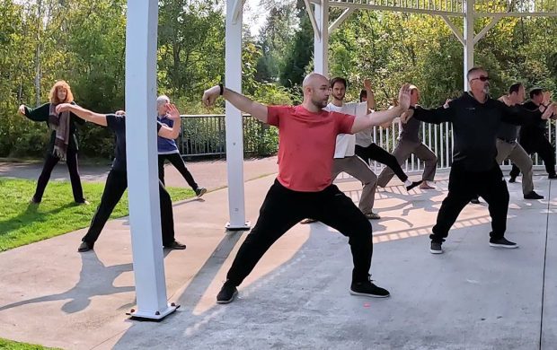 Personas practicando tai chi en un parque.